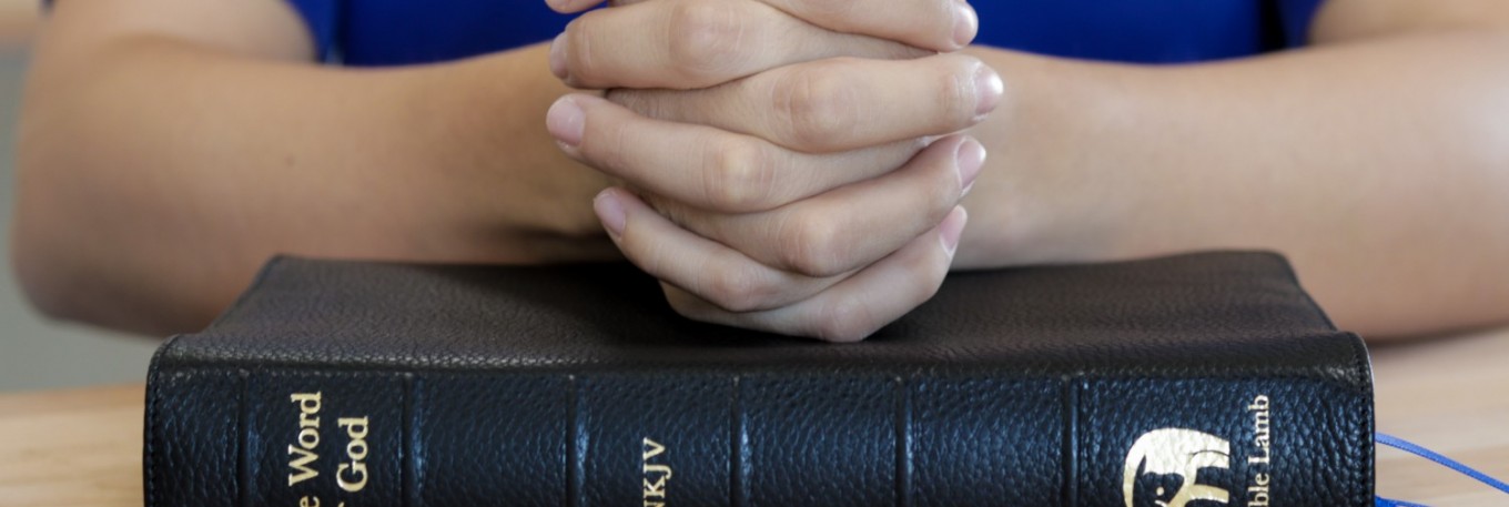 Clasped Hands and Bible